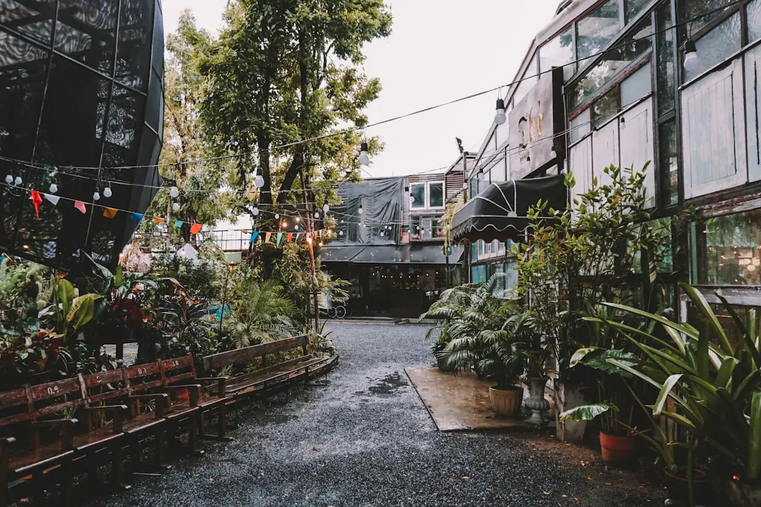 Bacs de potager urbain avec tomates cerises, salades et fraisiers dans une cour lumineuse et conviviale