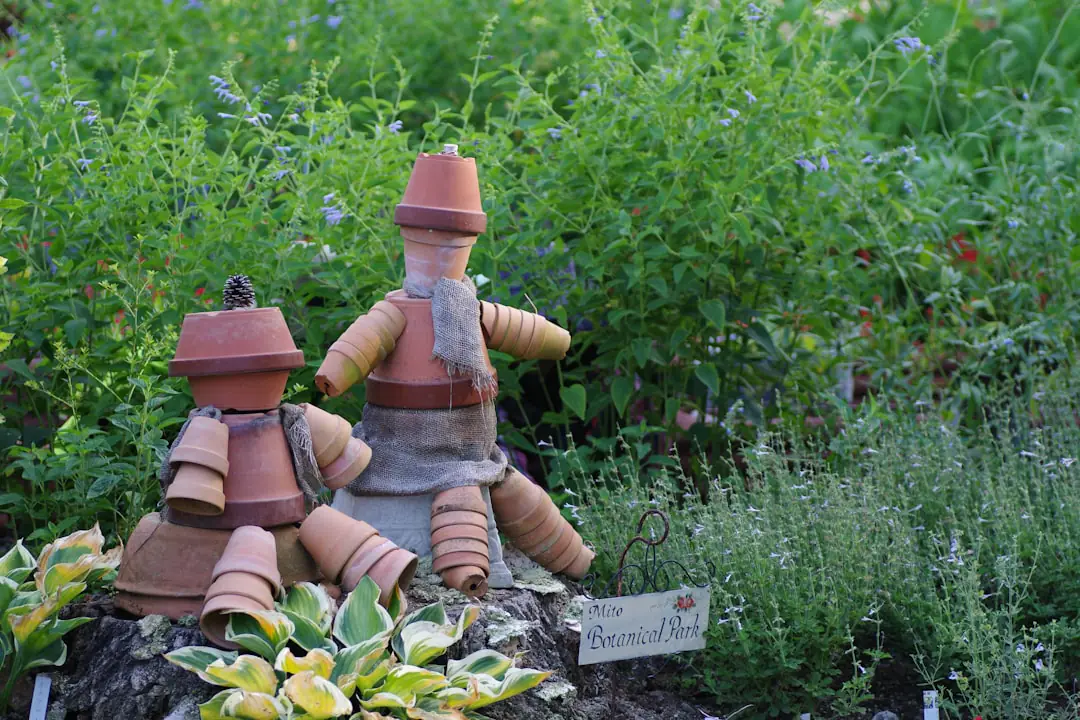 Jardin français en novembre avec potager paillé, arbres plantés et pots protégés près d’un mur lumineux