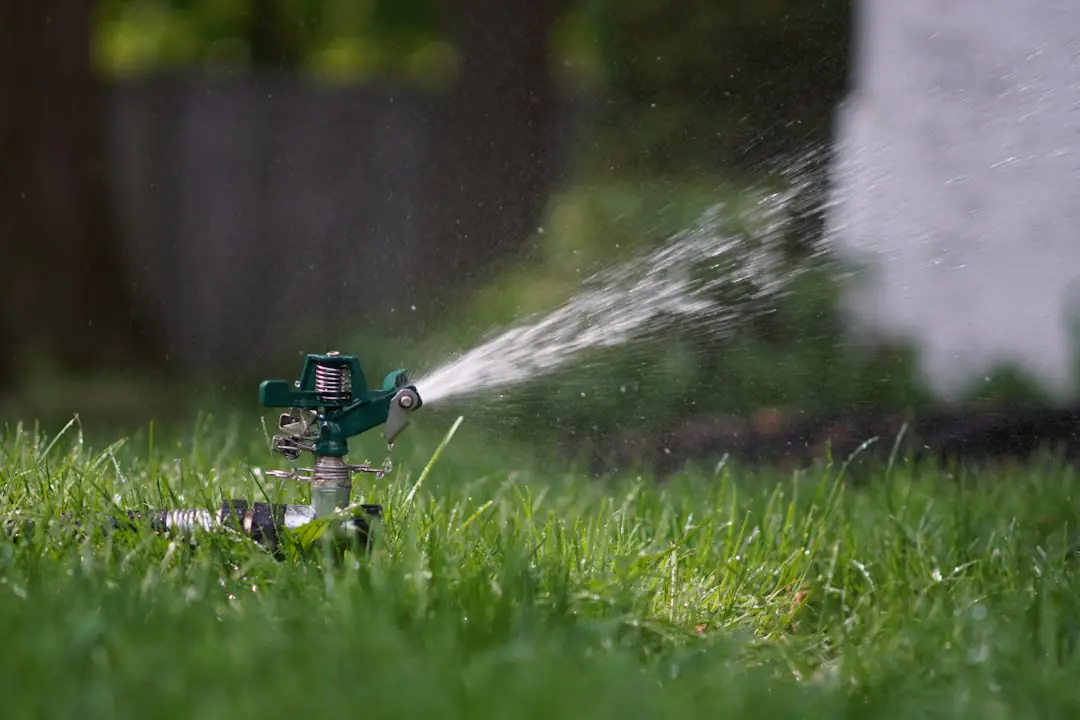 Jardinier aérant puis regarnissant une pelouse de jardin français par une douce journée de septembre