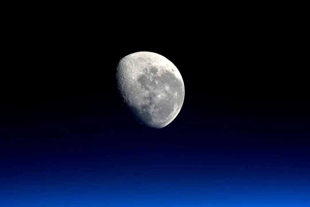 Jardinier semant des pois sous voile dans un potager français en février, au lever d’une Lune pâle
