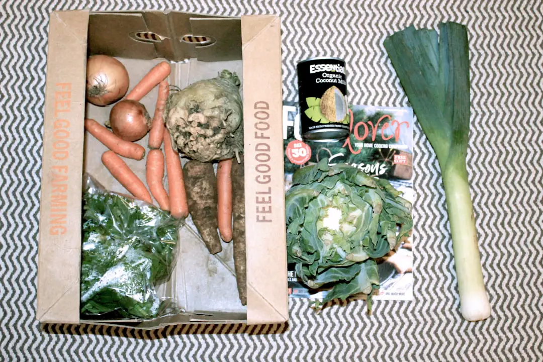 Kit de jardinage posé sur une table en bois, avec transplantoir, sécateur et gants dans un jardin français