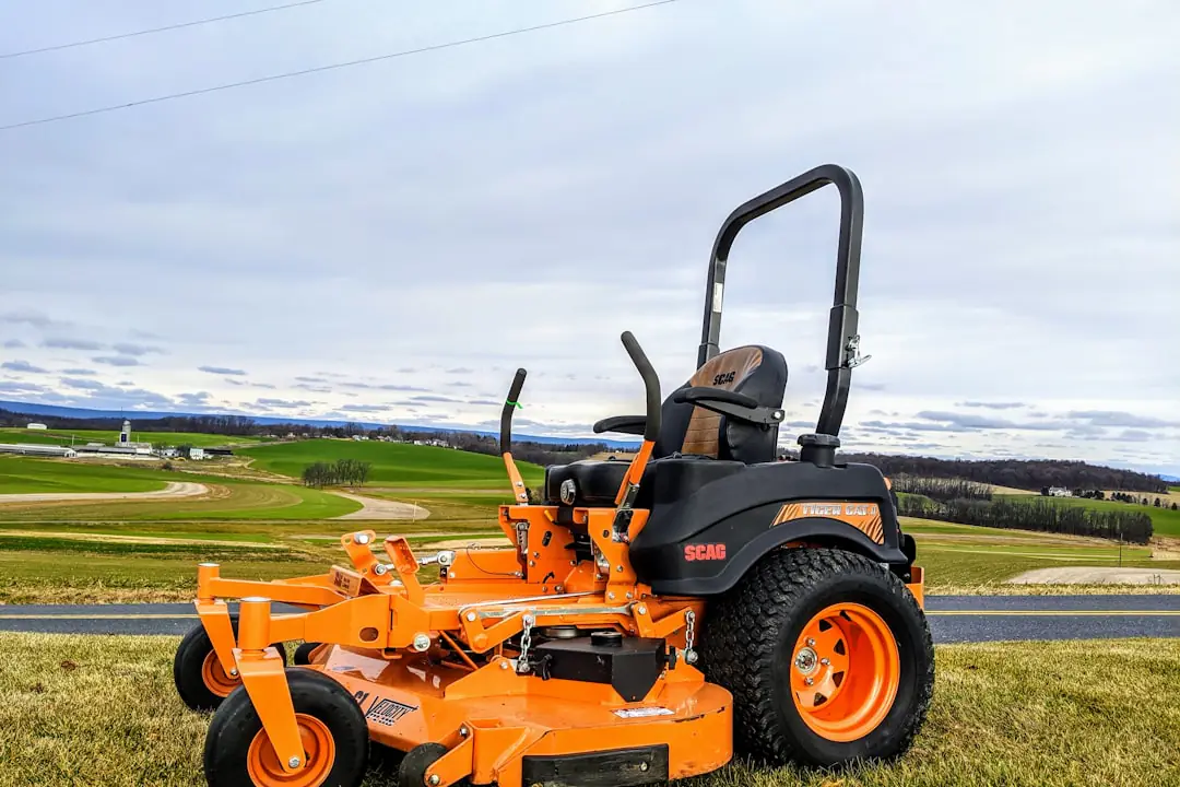 Tondeuse électrique compacte utilisée sur une pelouse de petit jardin français, près de massifs fleuris