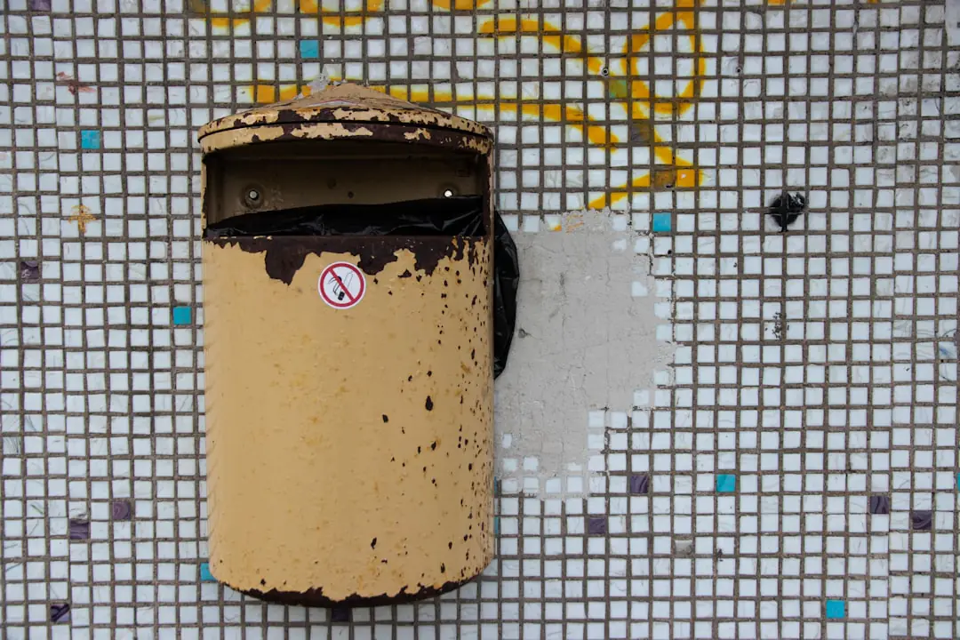 Bac à compost en bois dans un jardin, entouré de feuilles sèches et d’épluchures végétales triées