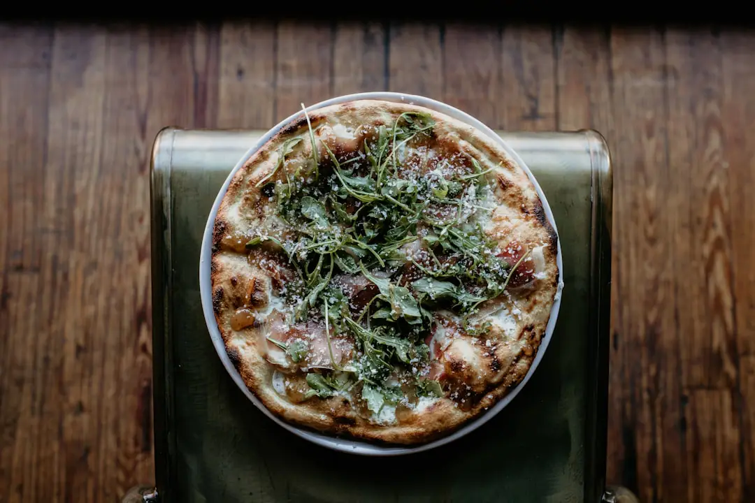 Table en bois dressée dans un jardin français avec herbes fraîches, plats à partager et convives réunis