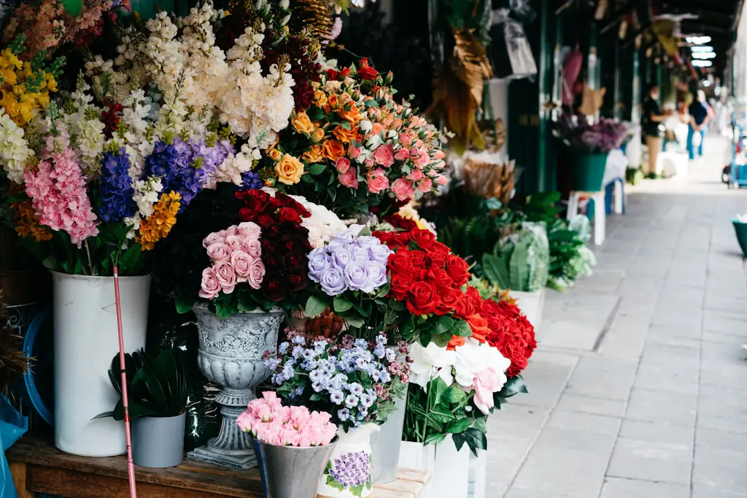 Devanture fleurie d’un fleuriste de quartier avec bouquets de saison et seaux de fleurs fraîches