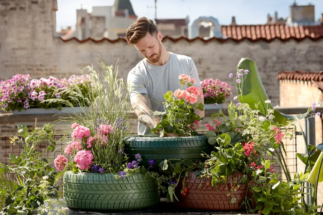 Jardinier comparant un sécateur et des outils de jardin manuels sur une table en bois dans un jardin français