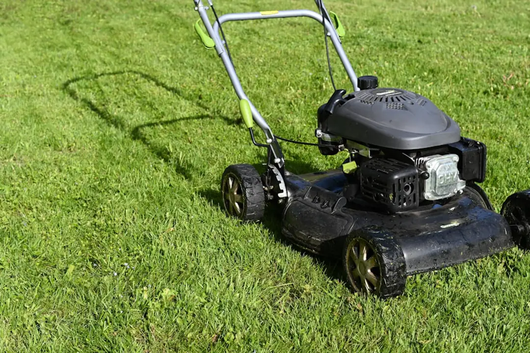 Jardinier filmant l’état d’une tondeuse sur une allée sèche avant de la prêter à son voisin
