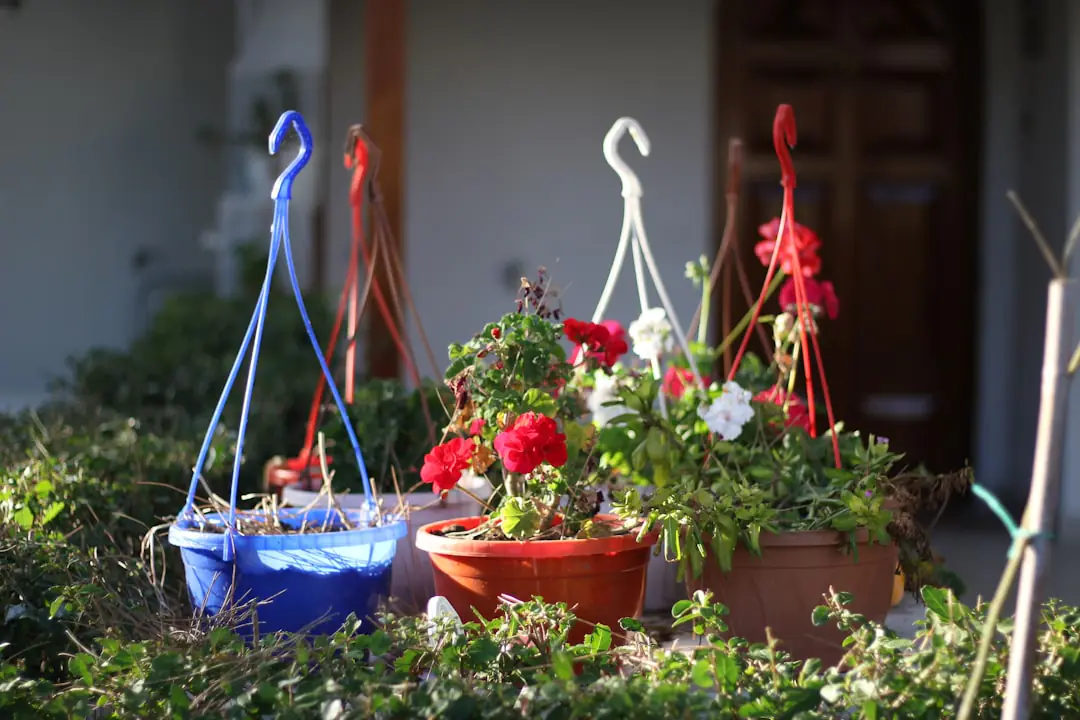 Gants fleuris, sécateur et arrosoir métallique élégant posés sur une table de jardin en bois clair