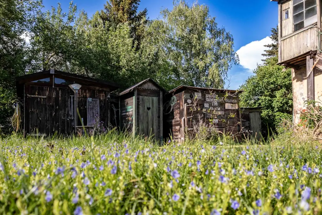 Potager écologique méditerranéen paillé avec composteur et bacs de tri dans un jardin lumineux près du littoral