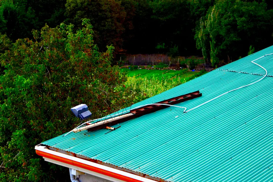 Potager en bacs légers sur un toit-terrasse à Jeypore, avec légumes, paillage et réserve d'eau couverte.