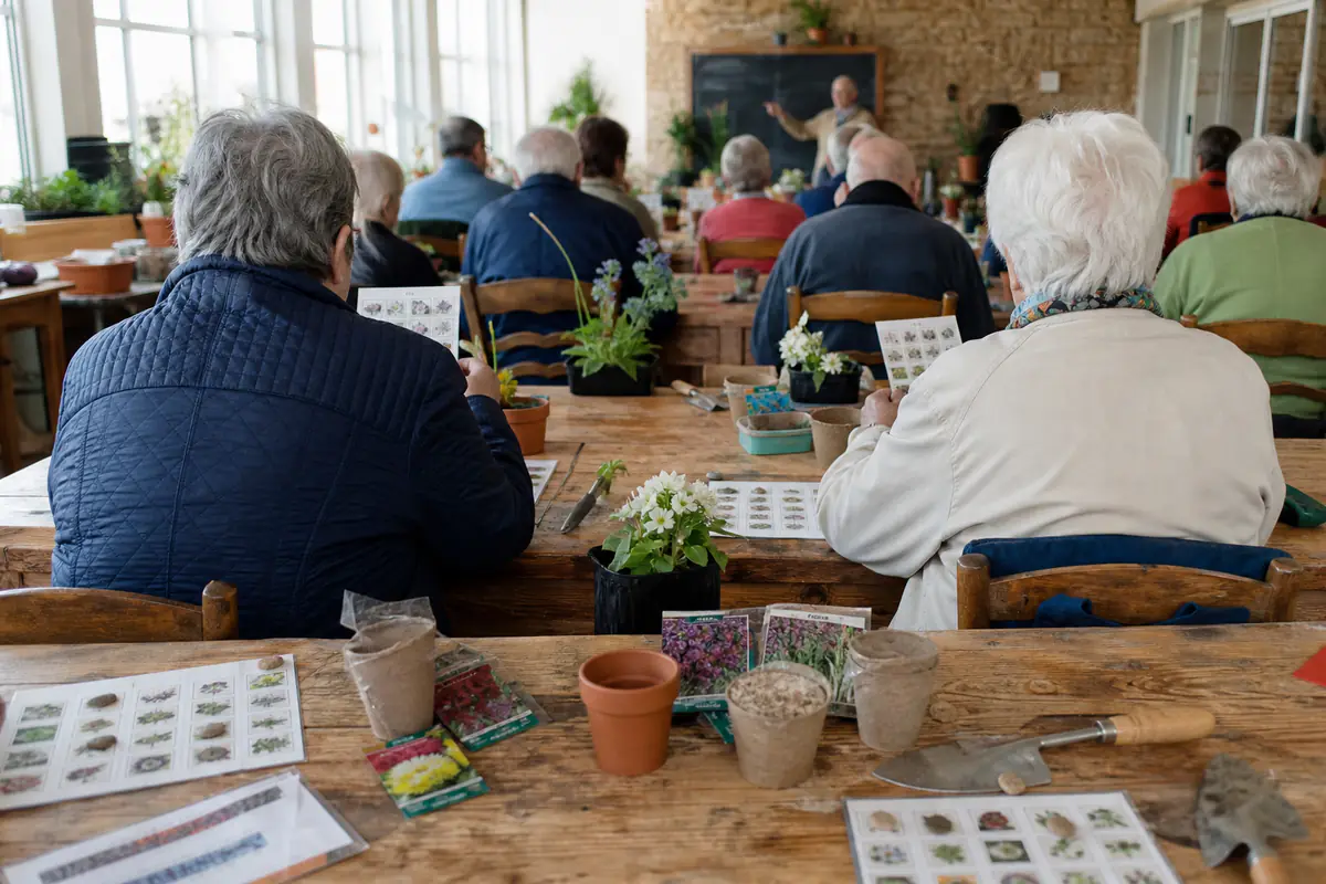 Jardiniers de tous âges cochant des cartons fleuris lors d’un loto convivial dans une salle lumineuse