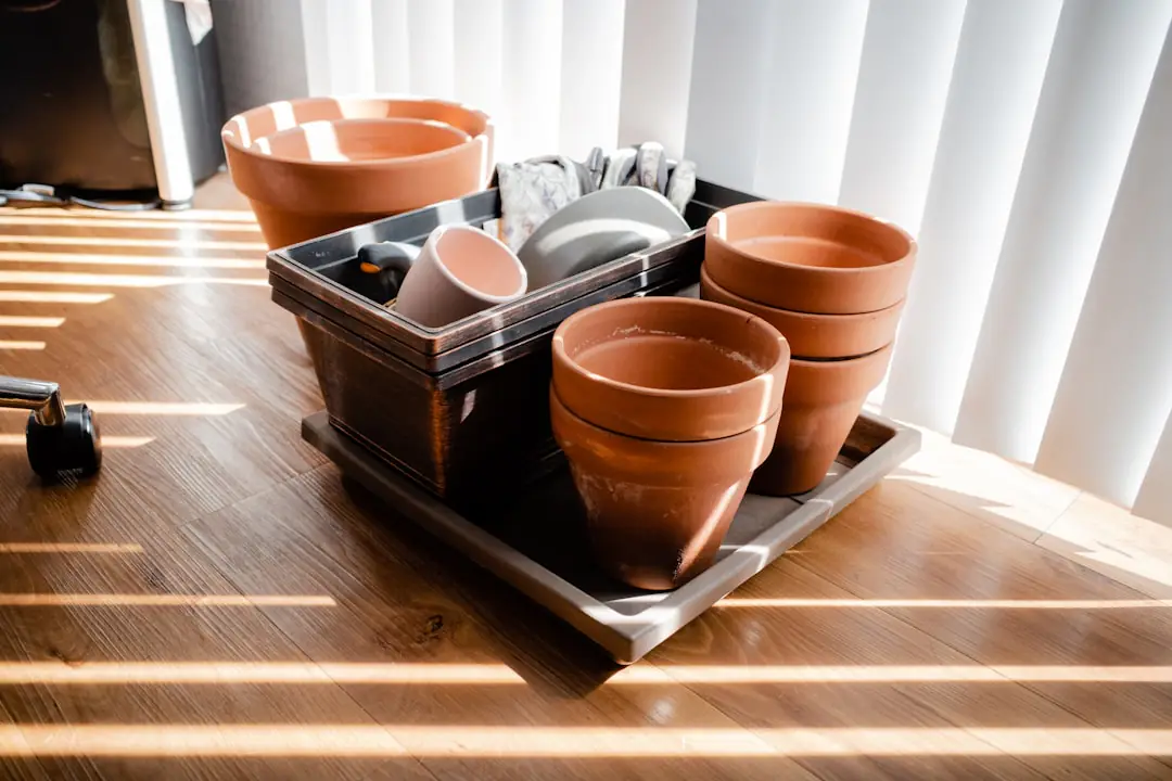 Kit de jardinage avec transplantoir, griffe, sécateur et gants posés sur un établi de jardin en bois