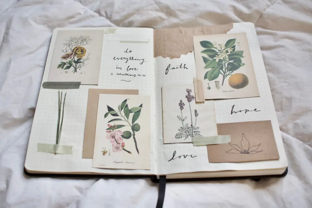 Livre de jardinage ouvert sur une table en bois, près de fleurs mellifères visitées par deux papillons