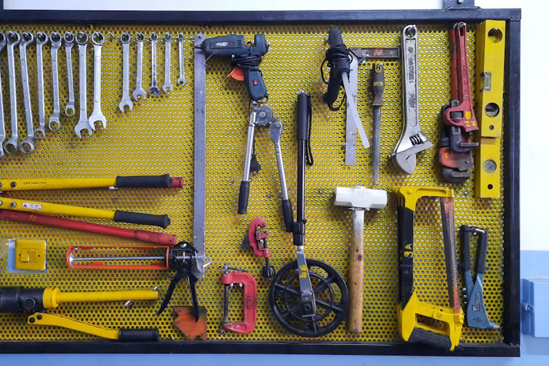 Coffret rigide ouvert sur un établi de jardin avec sécateur, transplantoir, gants et attaches rangés par zones