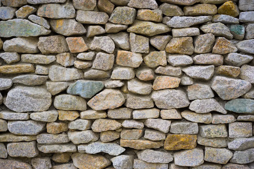 Ancien mur de pierres écroulé transformé en talus de vivaces fleuries dans un jardin français lumineux