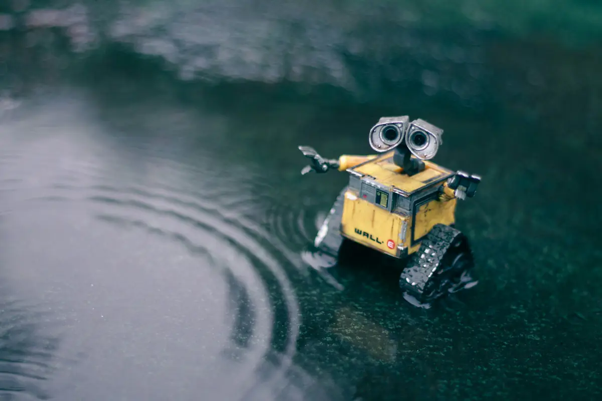 Robot-tondeuse en fonctionnement sur une pelouse familiale bordée de massifs, en plein jour dans un jardin français