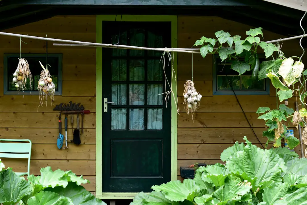 Enfants accompagnés remplissant un bac potager et un composteur en bois dans un jardin collectif.