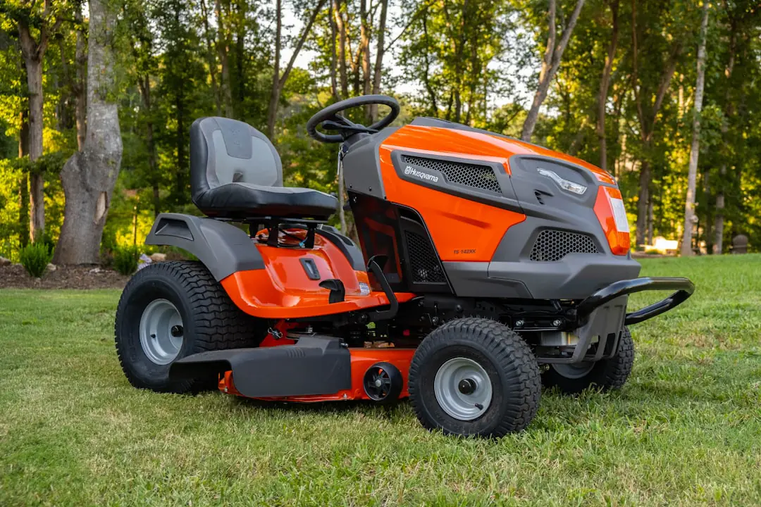 Robot tondeuse intelligent en fonctionnement sur une pelouse française bordée de vivaces, par temps sec d’automne