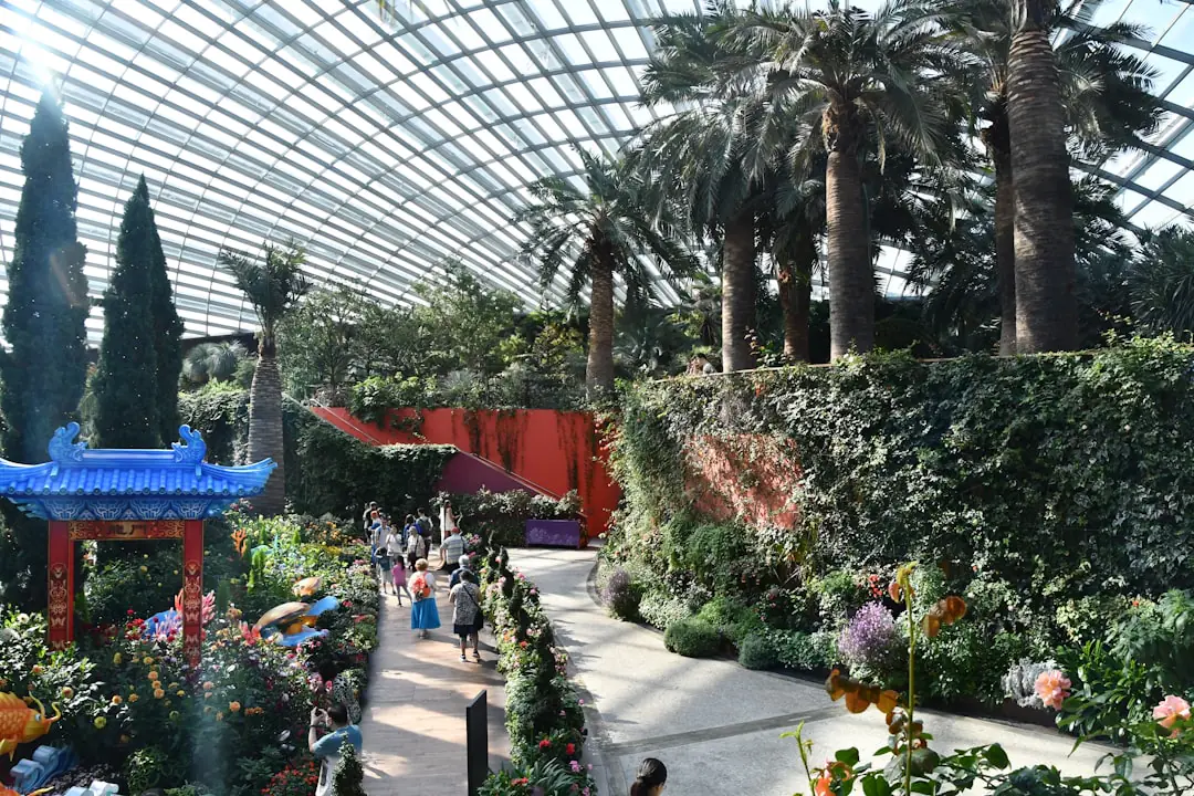 Visiteur prenant des notes devant des plantes et outils lors d'un salon du jardin lumineux et organisé