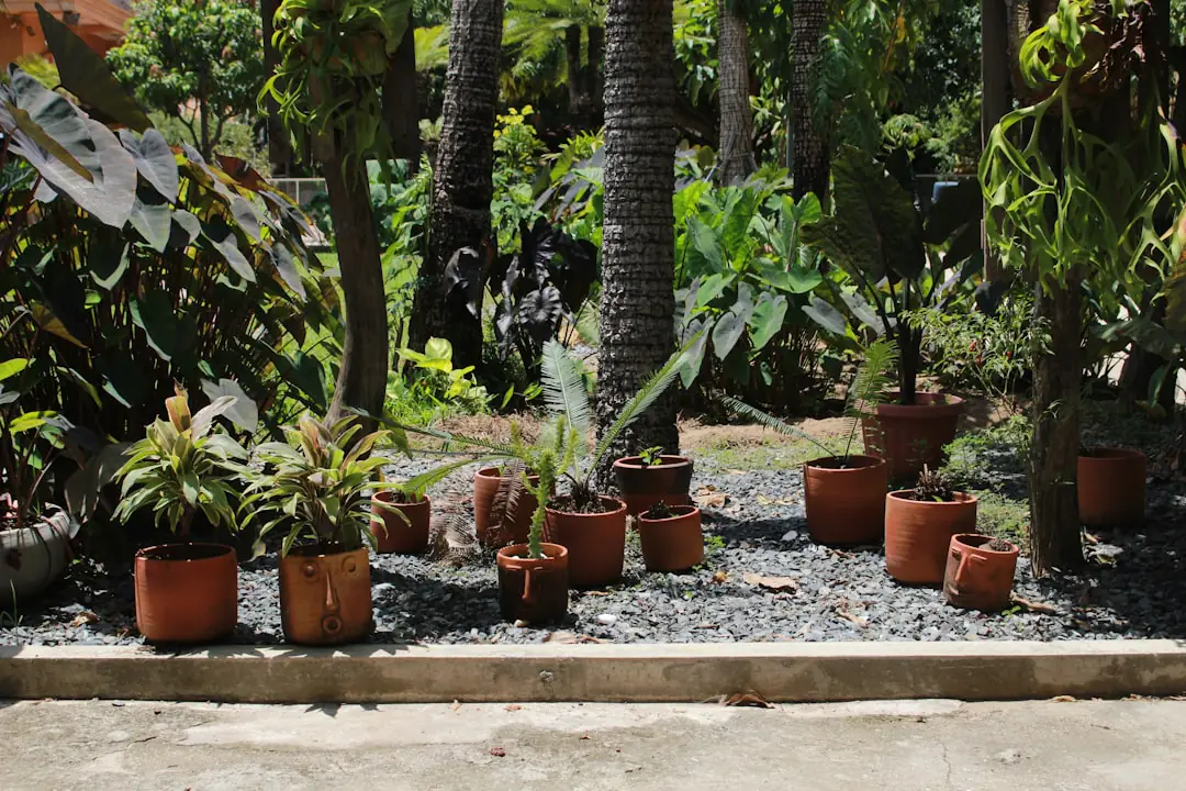 Petit groupe réuni autour d’une table de semis dans un jardin français fleuri au printemps, avec outils manuels et plants étiquetés.