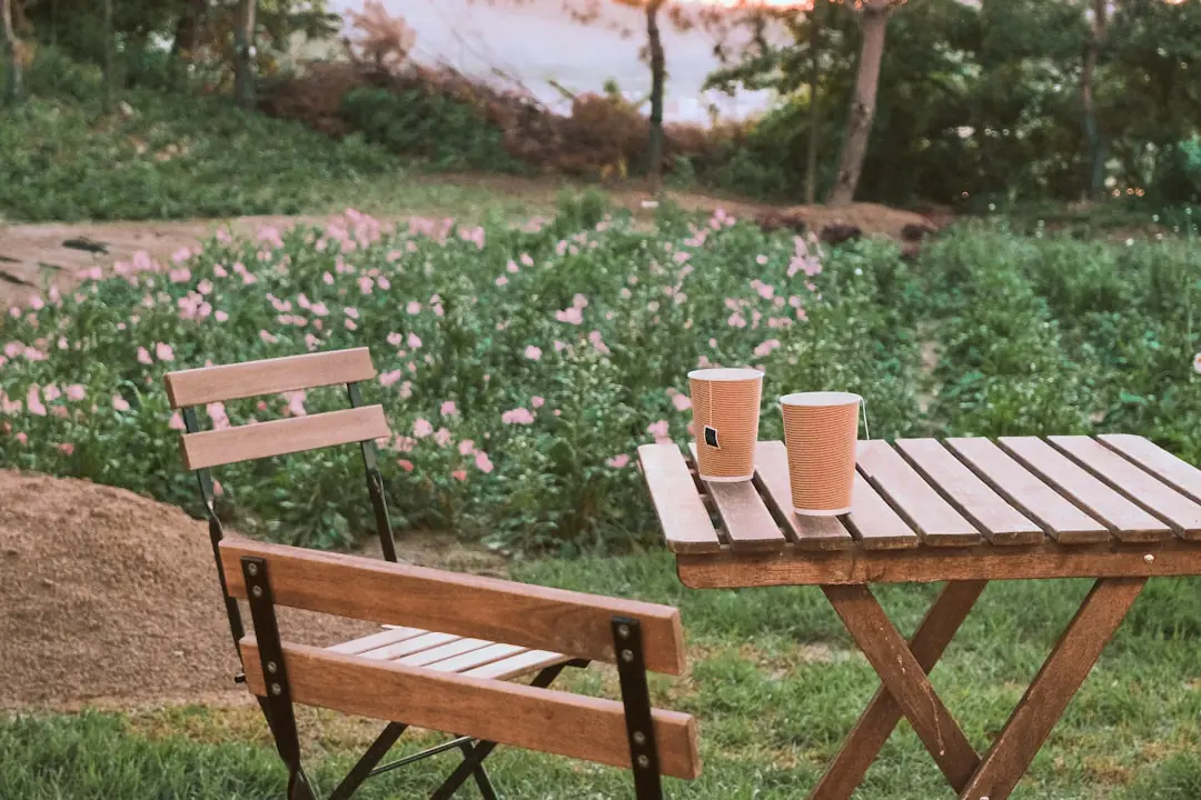 Table de café jardin sous un arbre, avec pots étiquetés, graines et jardiniers réunis dans un jardin français.