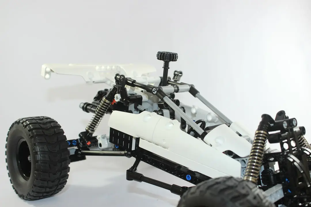 Robot tondeuse autonome travaillant de jour sur une pelouse bordée de massifs dans un jardin français