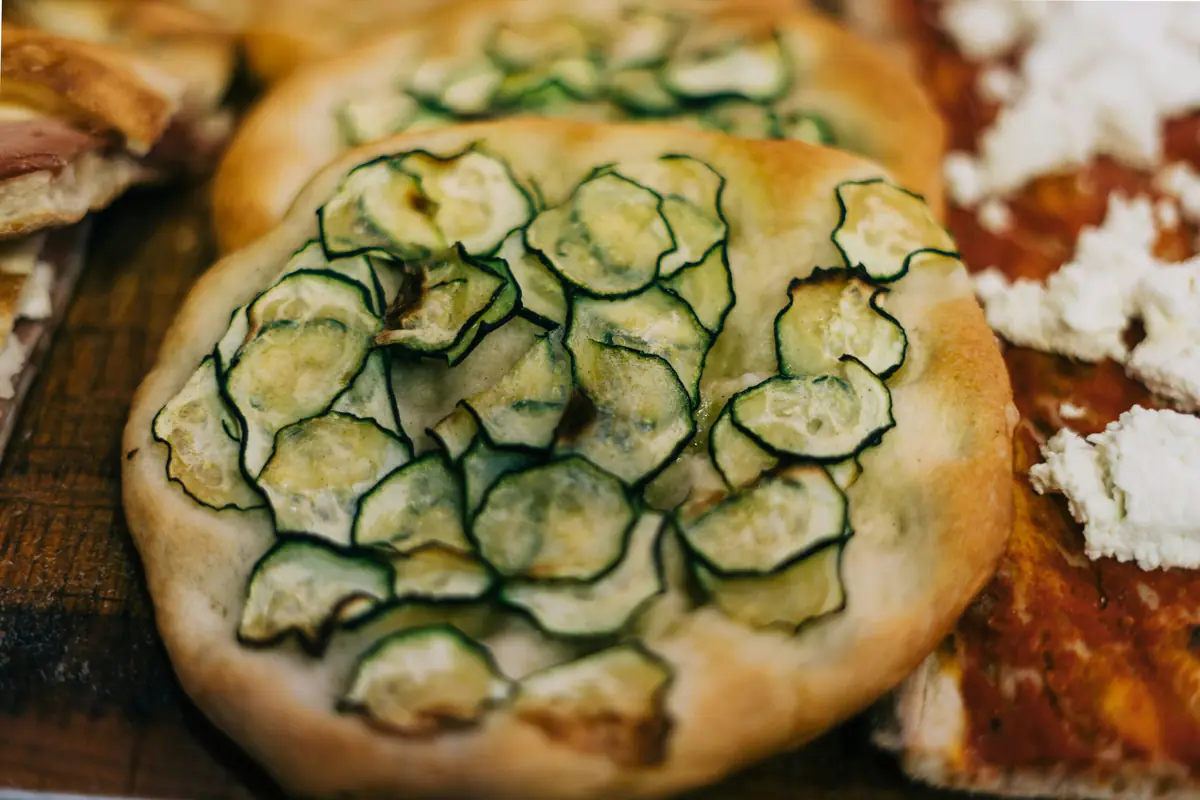 Pieds de courgettes paillés dans un potager français, avec fleurs jaunes et jeunes fruits prêts à récolter
